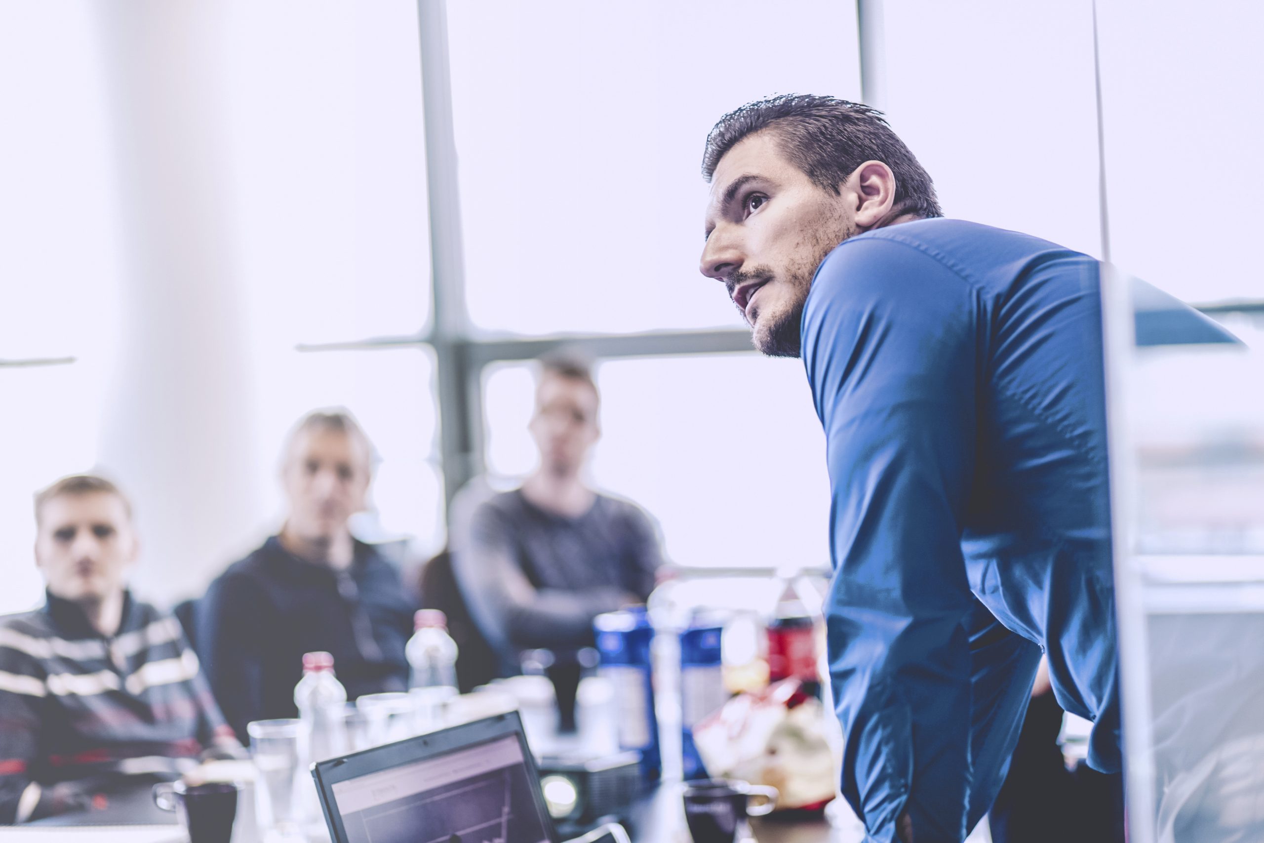 Business-Präsentation bei Corporate Meeting. Geschäftsmann, der eine Präsentation im Büro gibt. Unternehmensleiter, der seinen Kollegen bei einem Meeting oder einer internen Unternehmensschulung eine Präsentation hält und seinen Mitarbeitern Geschäftspläne erklärt.